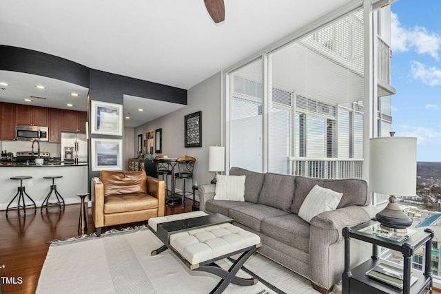 living area featuring dark wood-style floors, expansive windows, and recessed lighting