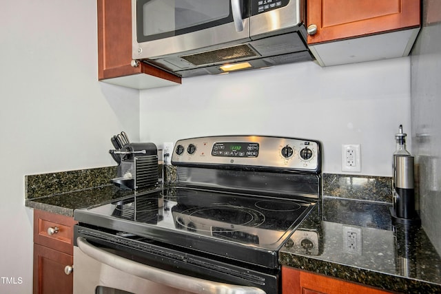 kitchen with stainless steel appliances and dark stone countertops