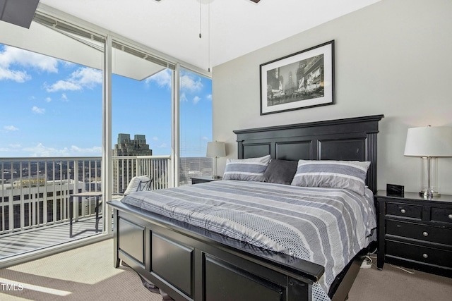 bedroom with expansive windows, a city view, and light colored carpet