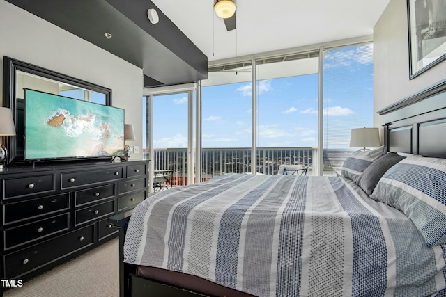 bedroom with access to exterior, expansive windows, multiple windows, and carpet