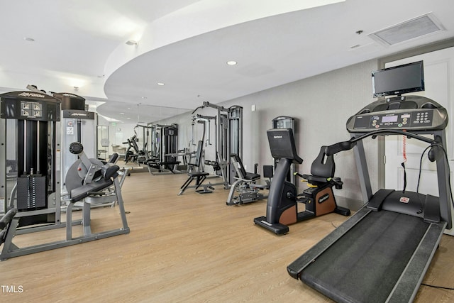 exercise room with wood finished floors, attic access, and recessed lighting