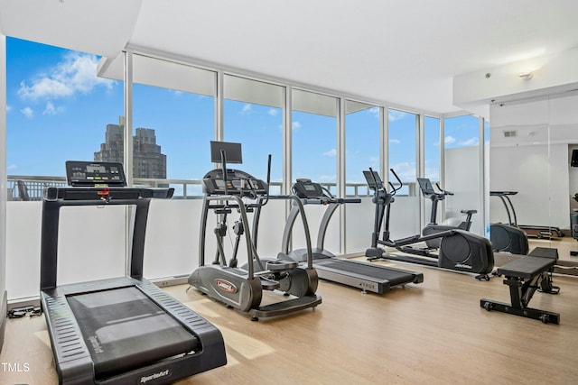 gym featuring visible vents, floor to ceiling windows, and wood finished floors