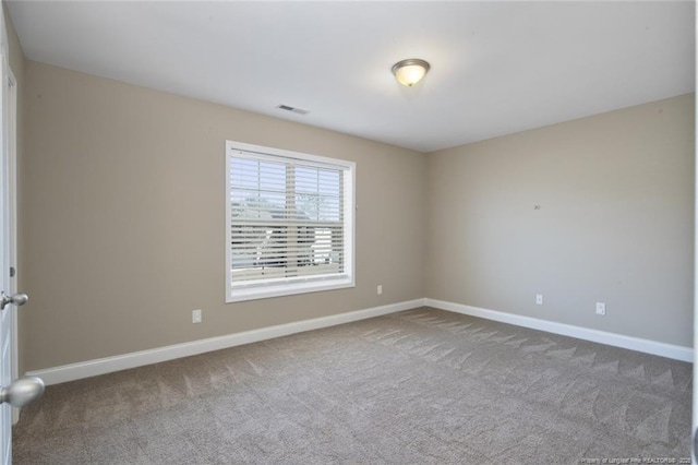 carpeted empty room with visible vents and baseboards