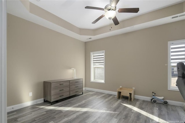 interior space featuring ceiling fan, wood finished floors, visible vents, and baseboards