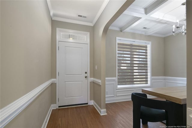 entrance foyer featuring ornamental molding, arched walkways, visible vents, and wood finished floors