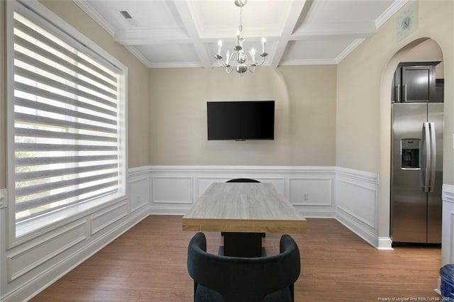 living area with beamed ceiling, plenty of natural light, and wood finished floors