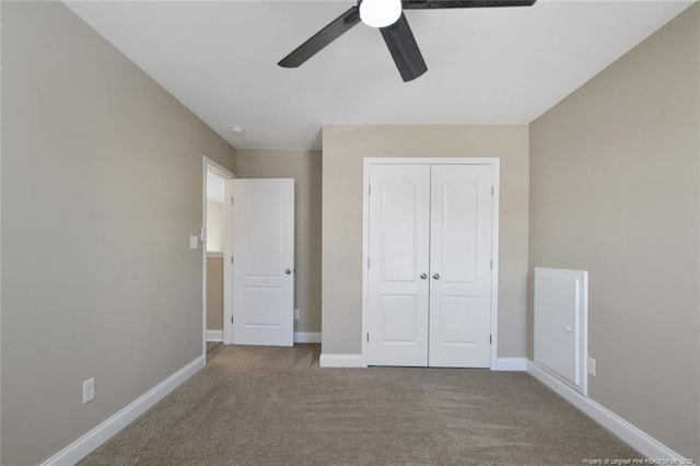 unfurnished bedroom with ceiling fan, carpet floors, a closet, and baseboards