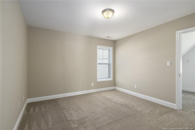 carpeted empty room featuring baseboards