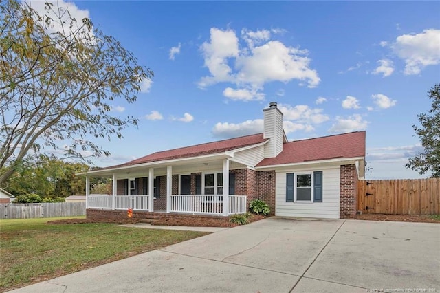 view of front of property featuring covered porch, a front yard, fence, and brick siding