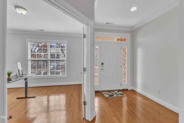 entrance foyer with baseboards, visible vents, crown molding, and wood finished floors