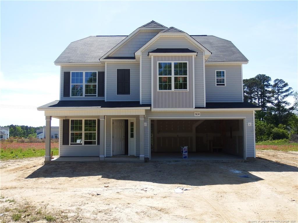 view of front of property with driveway, an attached garage, and covered porch