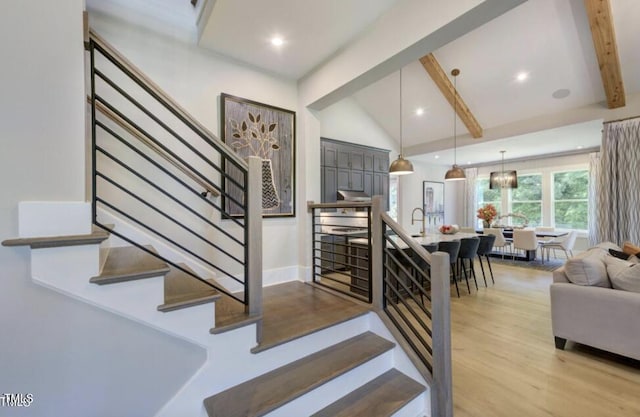 staircase with vaulted ceiling with beams, baseboards, wood finished floors, and recessed lighting