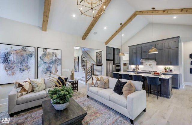 living area featuring a chandelier, stairway, light wood-style floors, high vaulted ceiling, and beam ceiling