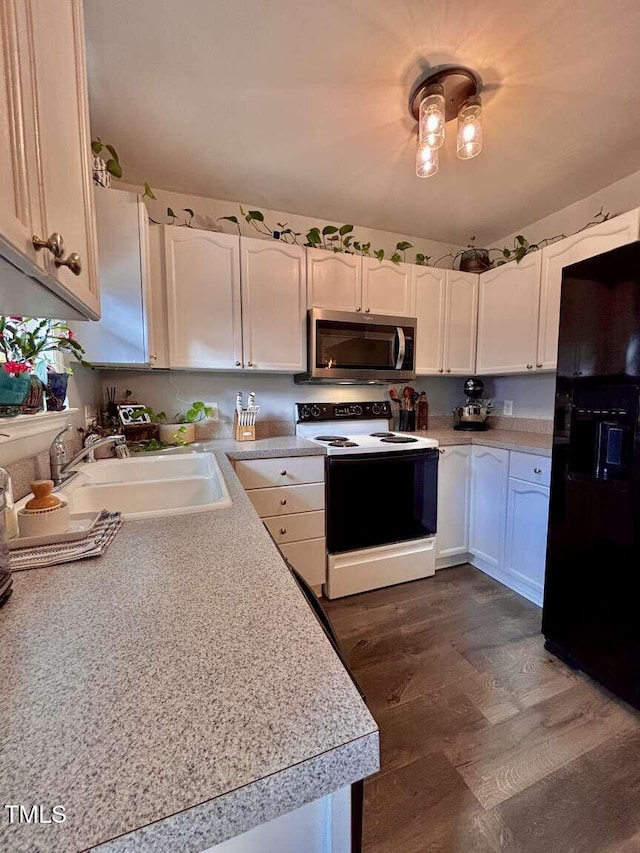 kitchen featuring stainless steel microwave, light countertops, black refrigerator with ice dispenser, a sink, and range with electric stovetop