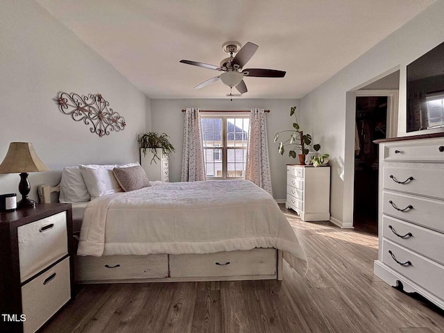 bedroom with ceiling fan, baseboards, and wood finished floors