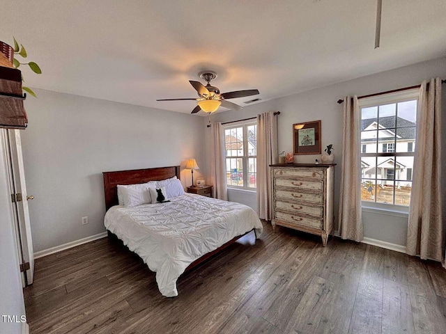 bedroom with baseboards, multiple windows, visible vents, and dark wood-type flooring