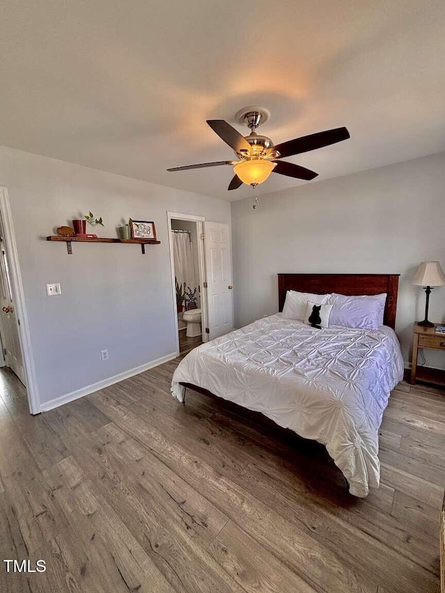 bedroom featuring a ceiling fan, baseboards, and wood finished floors