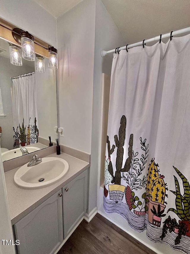 full bath with shower / bath combo with shower curtain, wood finished floors, and vanity