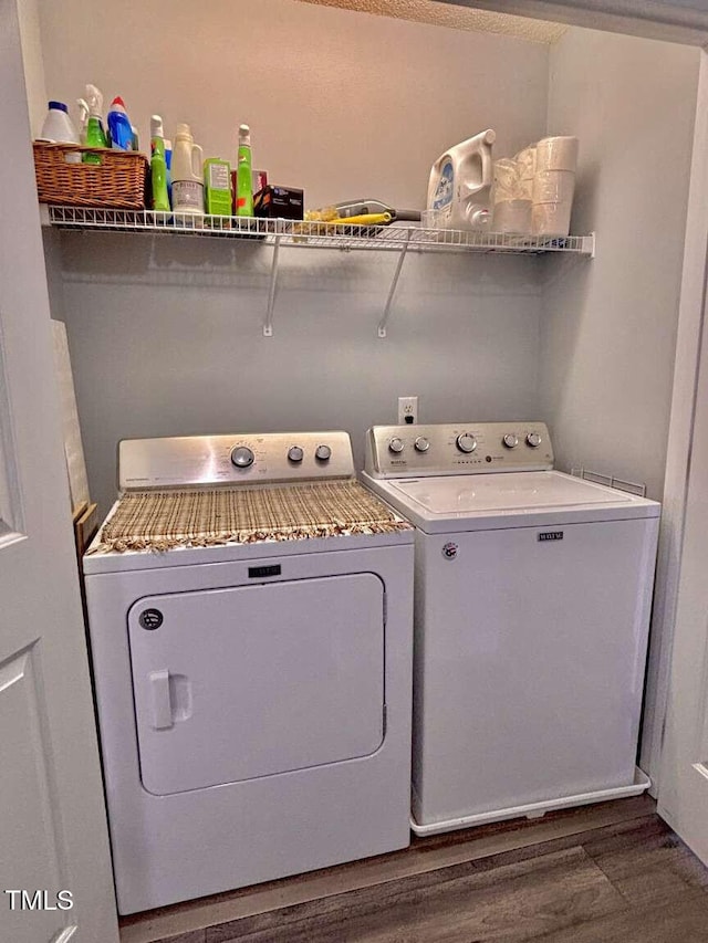 washroom with laundry area, washer and clothes dryer, and wood finished floors