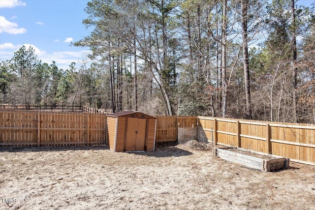 view of yard with a storage shed, a fenced backyard, and an outbuilding