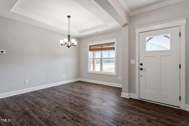 foyer with baseboards, a raised ceiling, dark wood finished floors, and ornamental molding