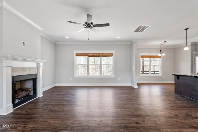 unfurnished living room with baseboards, visible vents, a tile fireplace, dark wood-style floors, and ornamental molding