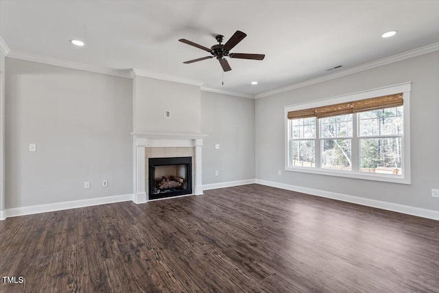 unfurnished living room featuring ornamental molding, dark wood-style flooring, a tiled fireplace, and baseboards