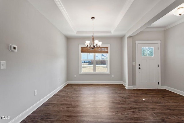 entryway featuring a chandelier, baseboards, ornamental molding, dark wood-style floors, and a raised ceiling