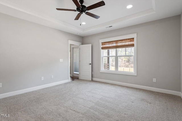 carpeted empty room featuring visible vents, baseboards, ornamental molding, a tray ceiling, and recessed lighting