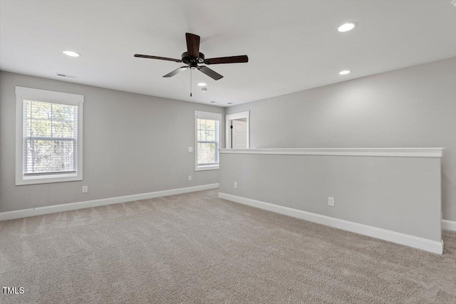 empty room featuring recessed lighting, light colored carpet, visible vents, and baseboards