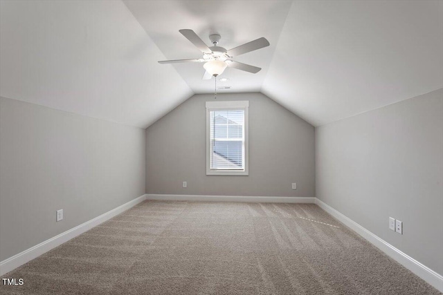 bonus room with lofted ceiling, light carpet, a ceiling fan, and baseboards