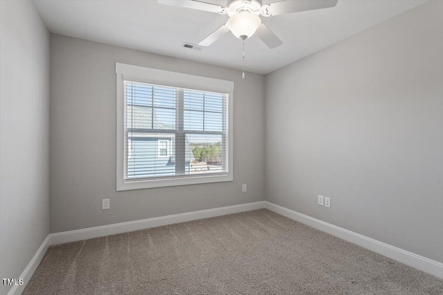 spare room featuring carpet floors, visible vents, ceiling fan, and baseboards