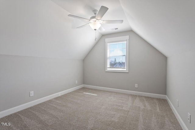 bonus room featuring light colored carpet, a ceiling fan, baseboards, vaulted ceiling, and visible vents