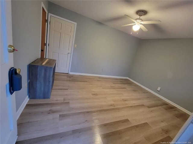 empty room with ceiling fan, baseboards, and wood finished floors