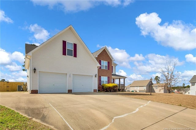 view of front facade featuring concrete driveway, central AC, and an attached garage