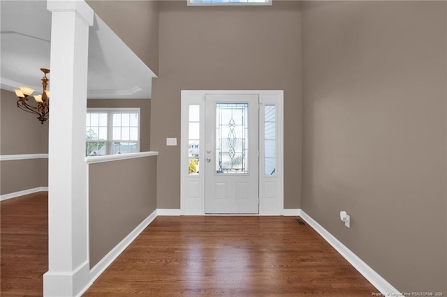 entryway featuring crown molding, wood finished floors, and baseboards