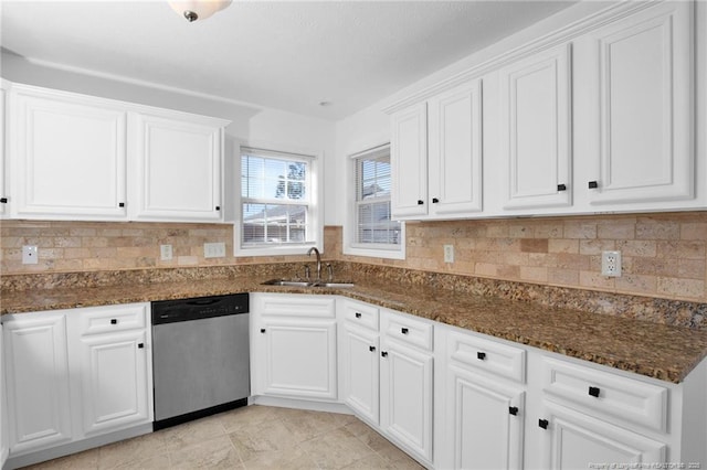 kitchen featuring a sink, white cabinetry, dark stone counters, and stainless steel dishwasher