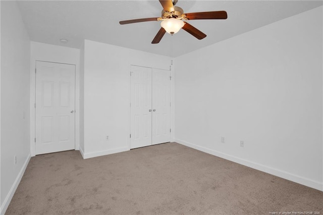 unfurnished bedroom featuring carpet floors, ceiling fan, baseboards, and a closet