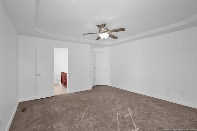 unfurnished bedroom featuring carpet floors, visible vents, baseboards, ornamental molding, and ensuite bath