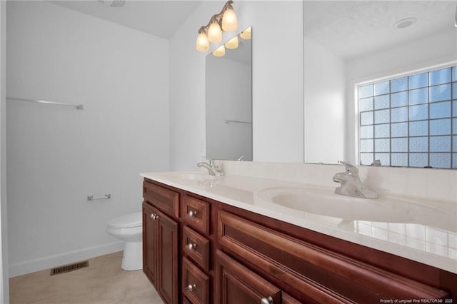 full bathroom with toilet, double vanity, visible vents, and a sink