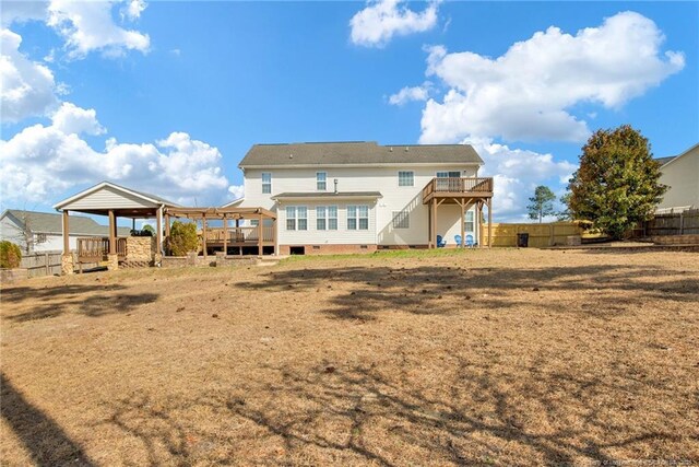 rear view of property with crawl space, fence, and a deck