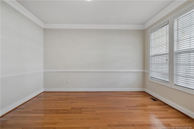 unfurnished room featuring ornamental molding, light wood-style flooring, and baseboards