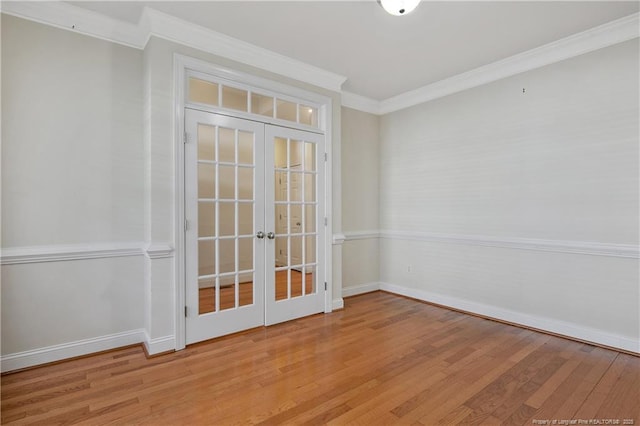 spare room featuring baseboards, ornamental molding, wood finished floors, and french doors