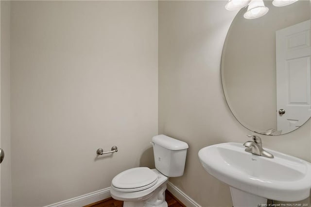 bathroom featuring a sink, toilet, and baseboards