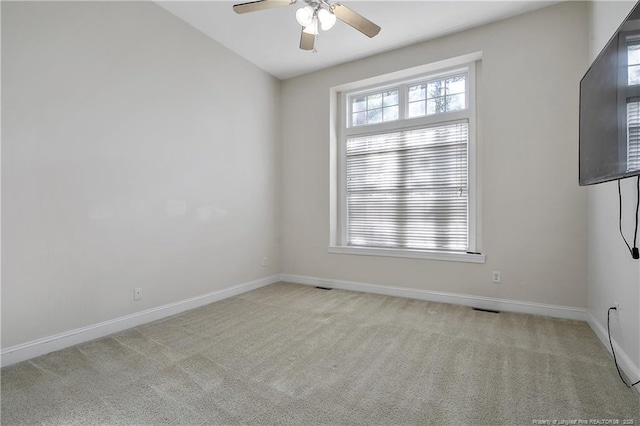 spare room featuring ceiling fan, carpet, and baseboards