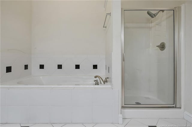 bathroom featuring a bath, a shower stall, and tile patterned flooring