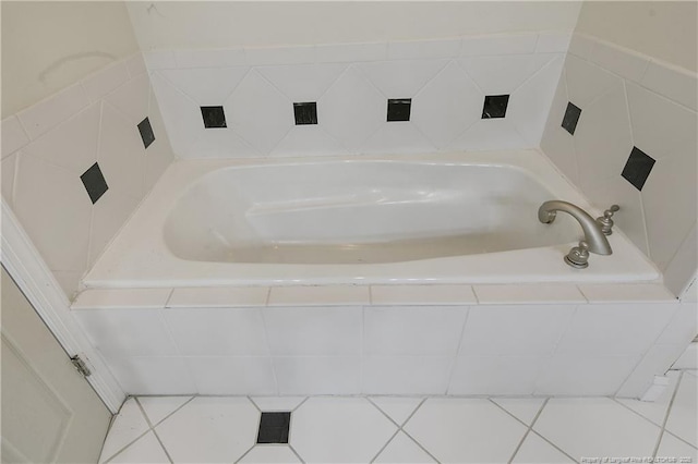 bathroom with a relaxing tiled tub and tile patterned flooring