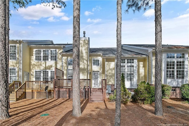 view of front of property featuring a chimney and a deck