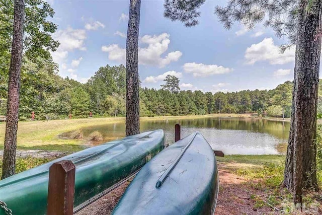 view of dock with a water view and a wooded view