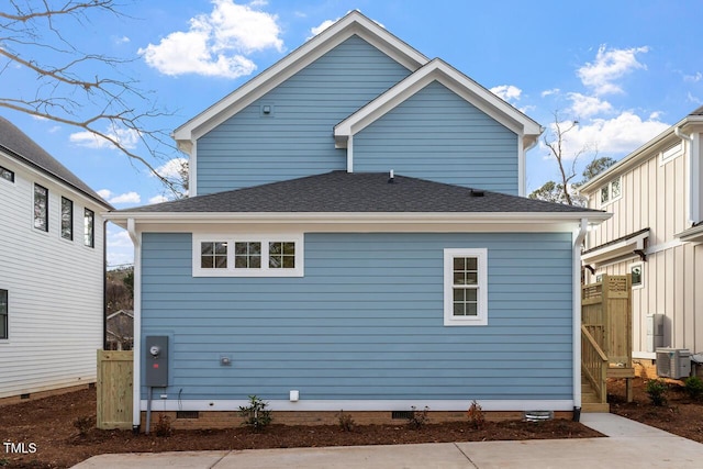 back of property with crawl space, cooling unit, and roof with shingles